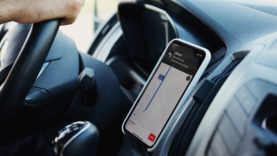 Close-up of a car dashboard with a smartphone showing GPS navigation for a route.